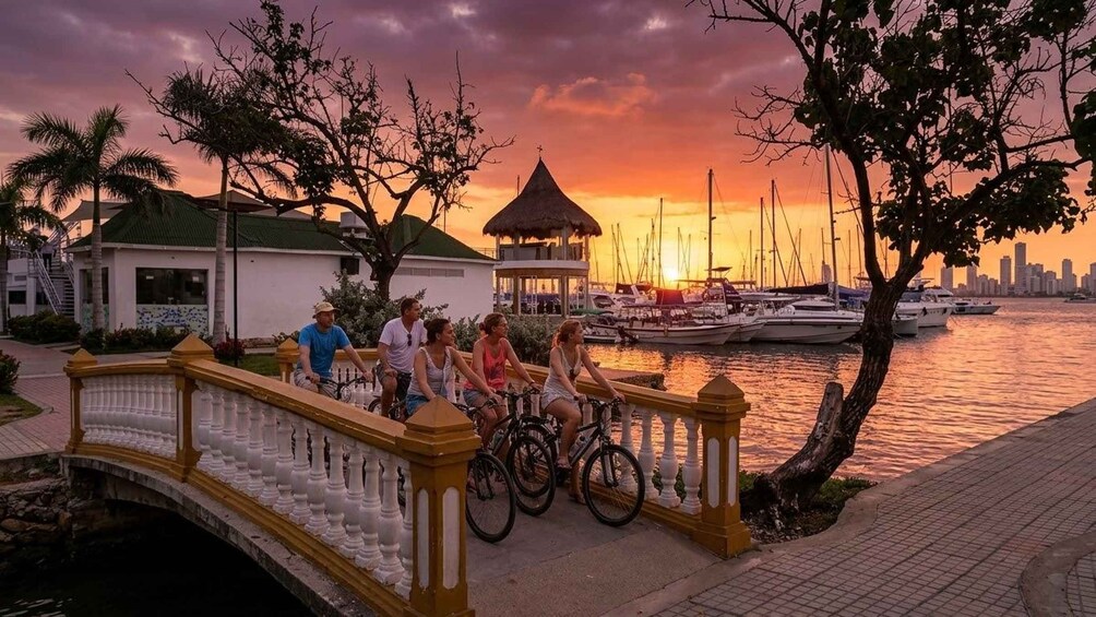 A sunset over a marina with boats, a bridge, and a city skyline in the background. 4