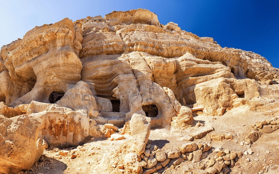 A rocky landscape with layered formations and caves. 1