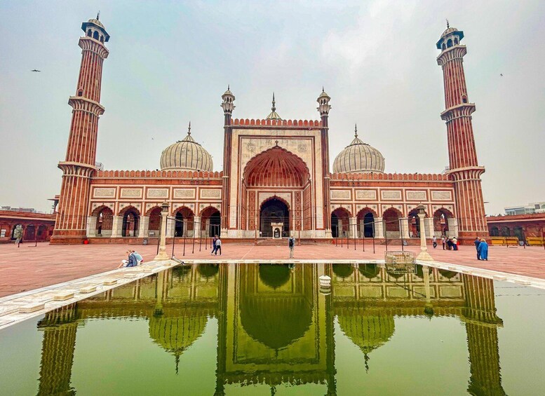 Une grande mosquée dotée de deux minarets, d’un dôme central et d’un bassin décoratif. 2