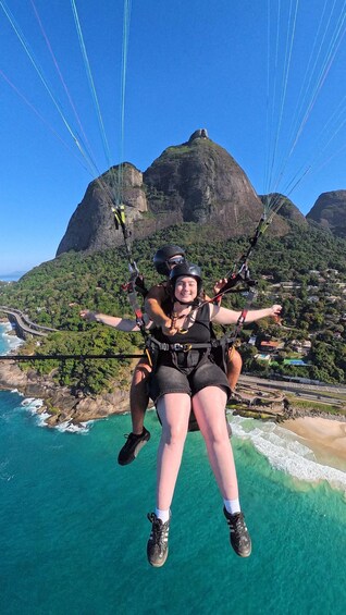 A person paragliding with a mountainous landscape in the background. 3
