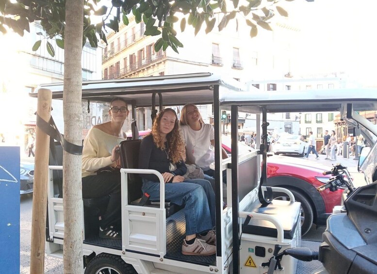 A group of people on a golf cart in an urban setting. 4