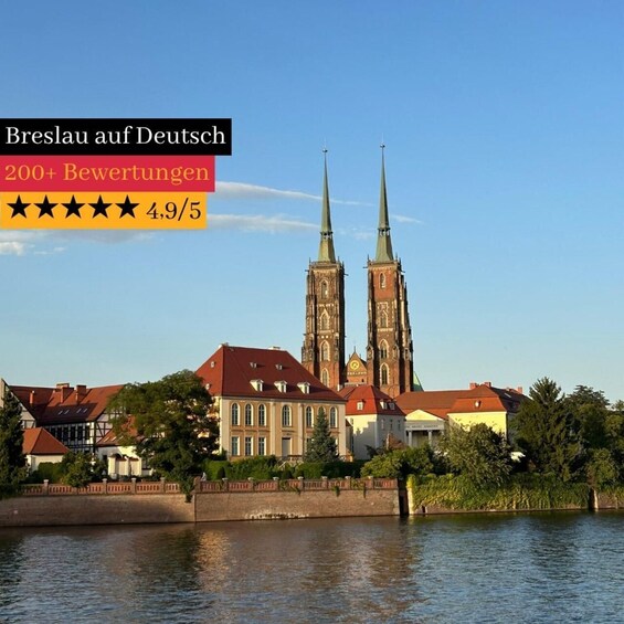 A historic church with two tall spires, surrounded by buildings and a river. 1