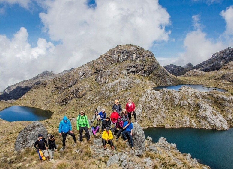 A group of hikers on a mountain peak with two lakes in the background. 4