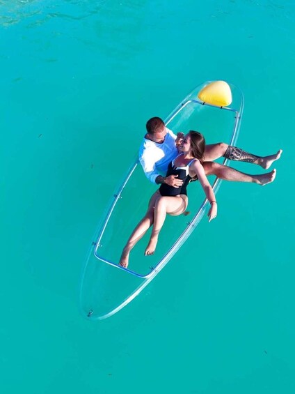 A couple on a transparent boat in turquoise water. 5