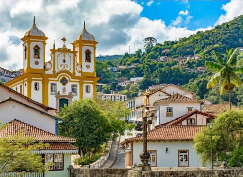 A church with two towers, surrounded by houses and a hillside. 4