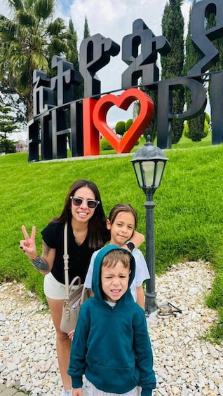 A family in front of a large sign with a heart symbol. 5