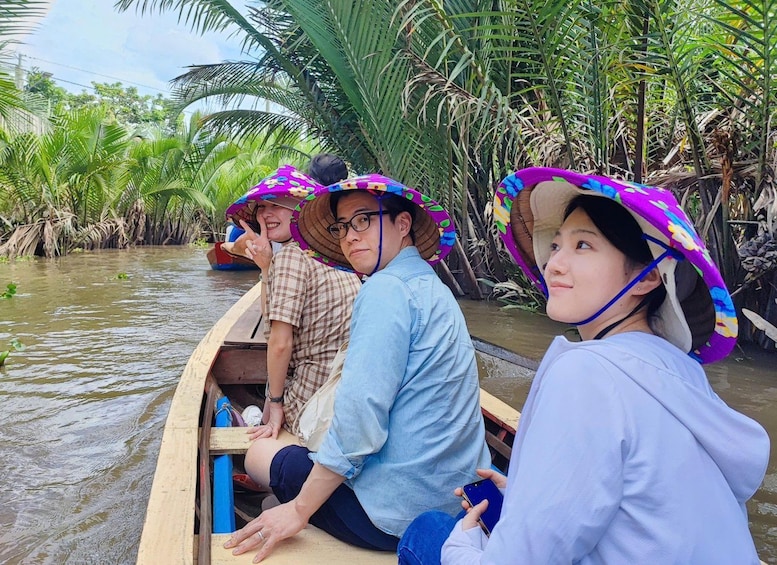 A group of people in a boat on a river surrounded by lush greenery. 1