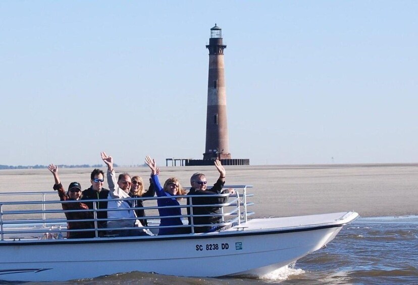 A boat with people raising their hands, a lighthouse in the background, and calm water. 1