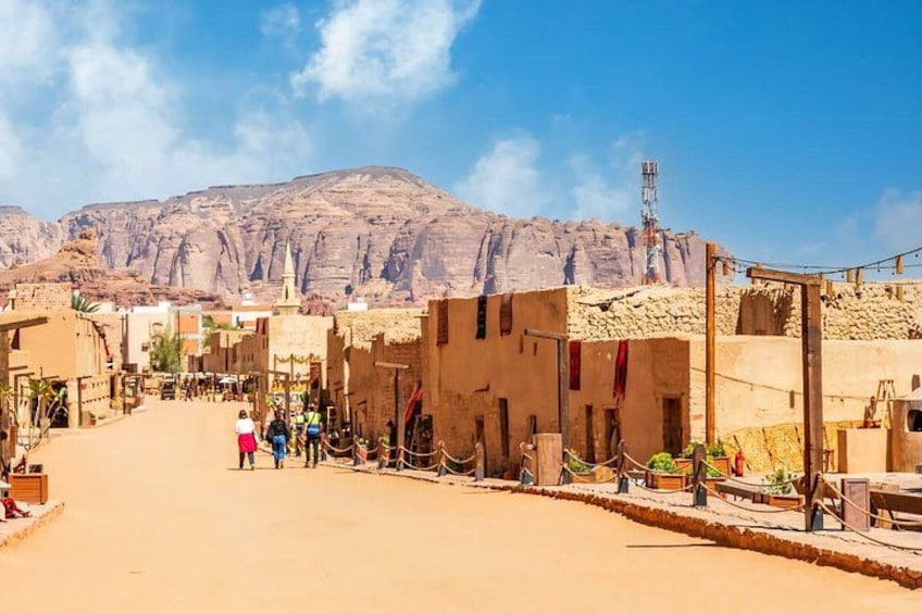 A desert town with buildings, a clear sky, and mountains in the background. 3