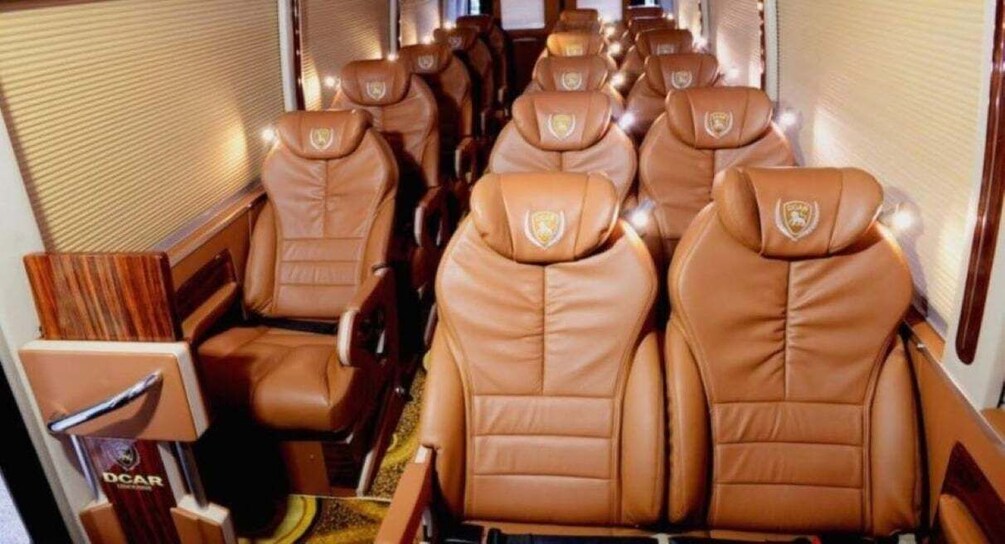 A row of brown leather seats with a logo on the headrest. 1