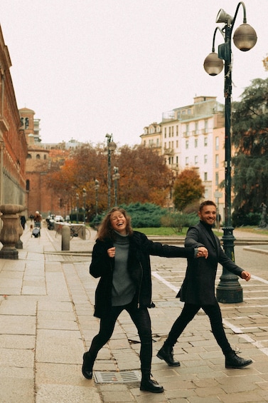 Two people walking on a city street with buildings and trees in the background. 3