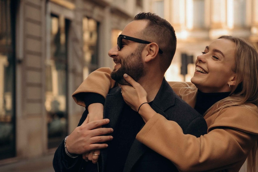 A person embracing another in an urban setting with buildings in the background. 5