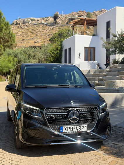 Musta Mercedes-Benz-merkkinen maasturi oli pysäköity mukulakivipolulle, ja taustalla kohosi vuoristo. 5