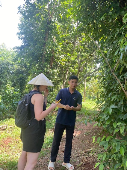 Two people walking on a forest trail surrounded by dense green foliage. 5