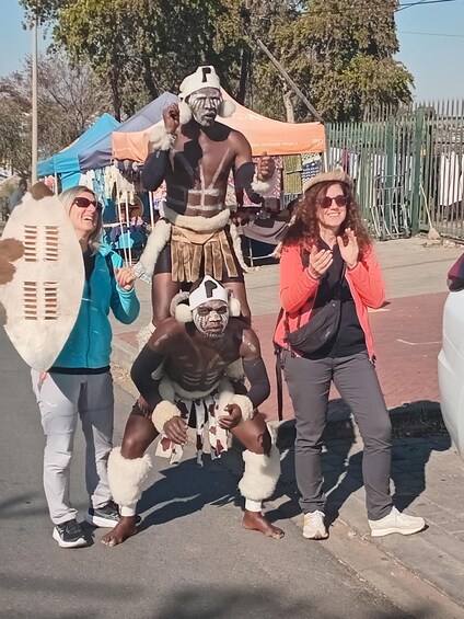 Three people posing with a person in a bear costume. 5