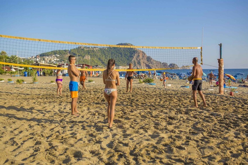 A beach volleyball game with players in swimwear. 2