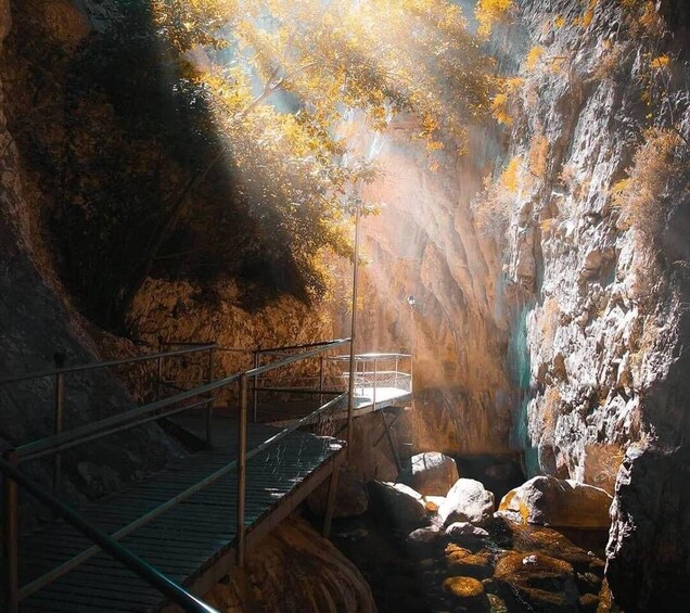 A cave with a metal staircase leading to a viewing platform. 1