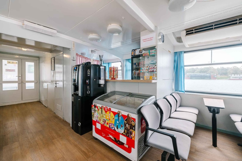 A clean, modern interior with a seating area, a vending machine, and a refrigerated display. 3