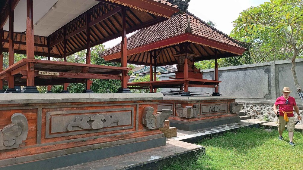 A traditional wooden pavilion with intricate carvings, set against a backdrop of lush greenery and a clear sky. 4