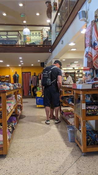 A man browsing textiles in a multi-level store. 5