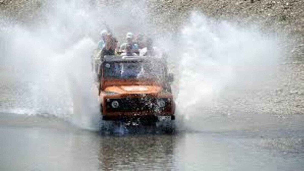 A vehicle driving through water, creating a large splash. 2
