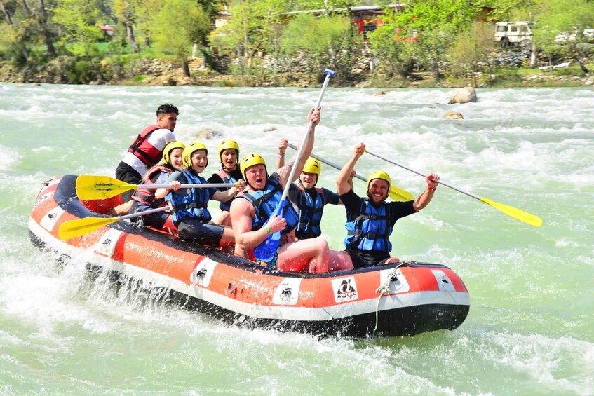A group of people in a white and red inflatable raft on a river. 1