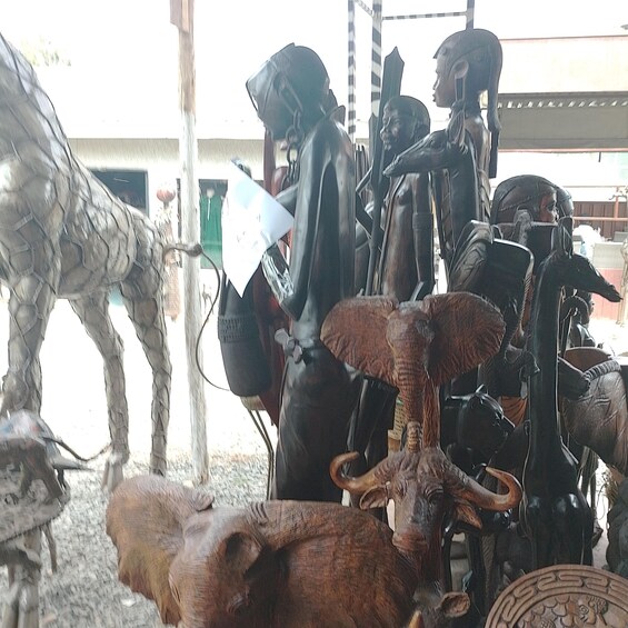 A collection of wooden sculptures, including a bull and a horse, in an outdoor setting. 2