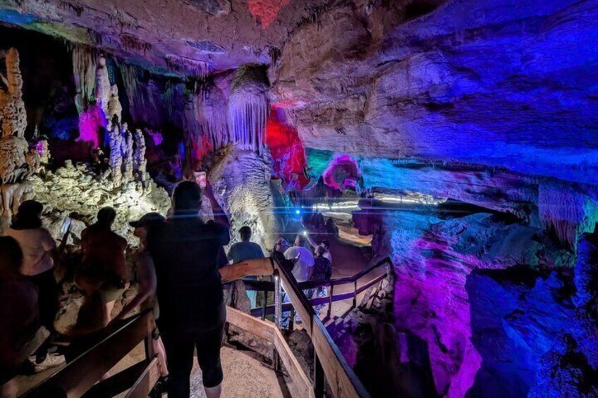 Una cueva con estalactitas y estalagmitas de colores, iluminada por luces artificiales. 4