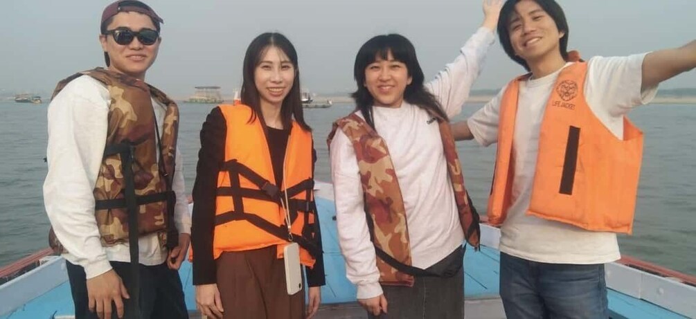 Four people on a boat wearing life jackets. 5