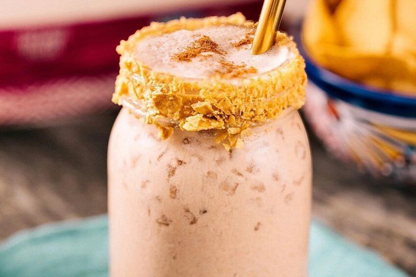 A jar of ice cream with a golden crust and a golden straw. 5