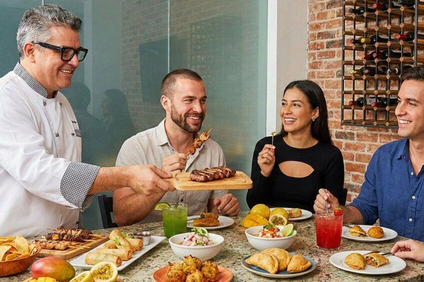 A group of people dining at a table with various dishes, a wine rack, and a glass of red drink. 4