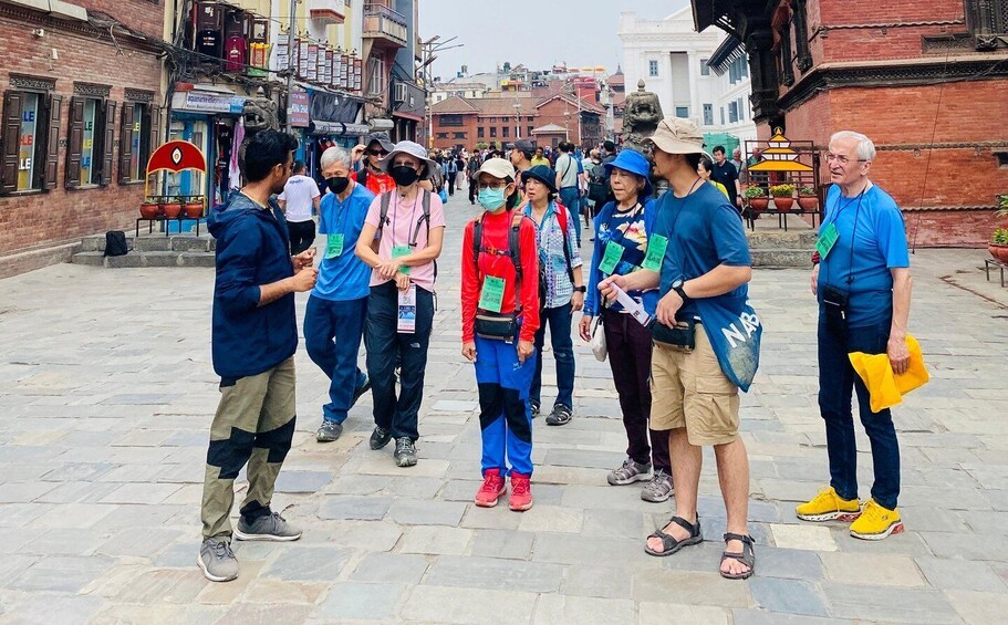 A group of people standing on a stone-paved street in an urban area. 4