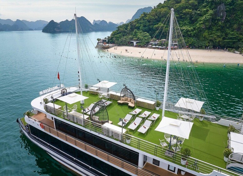 A cruise ship with a deck area featuring outdoor seating and a small garden. 2