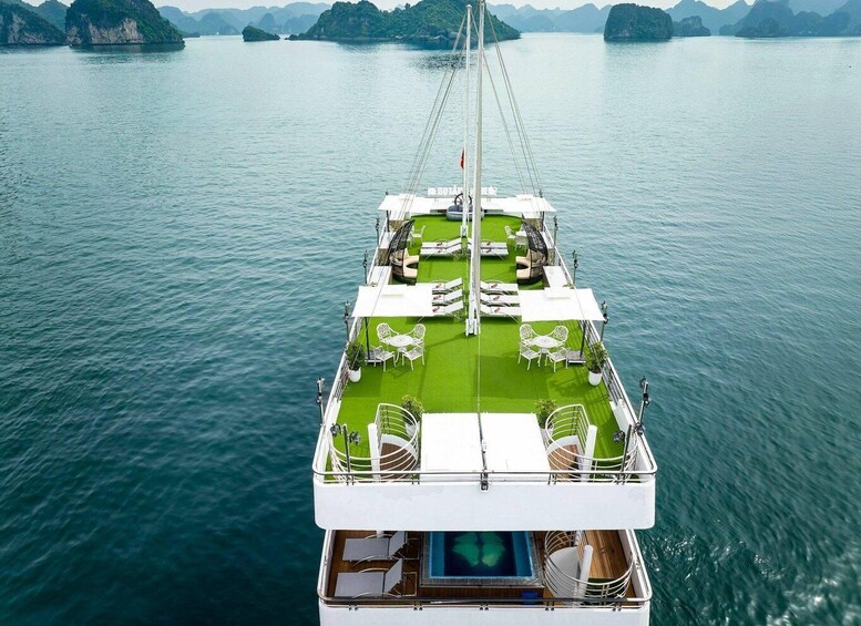 A boat with a green deck and white chairs. 5