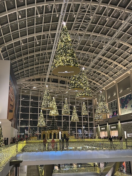 A shopping mall with large Christmas trees and illuminated ceilings. 1