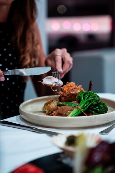 A person cutting food with a knife and fork. 3