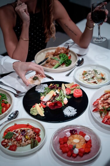 A table with various dishes, including seafood, salads, and a dessert. 4