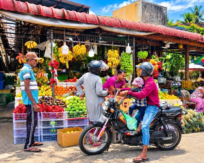 Un marché de rue avec des étals de fruits et des motos. 3