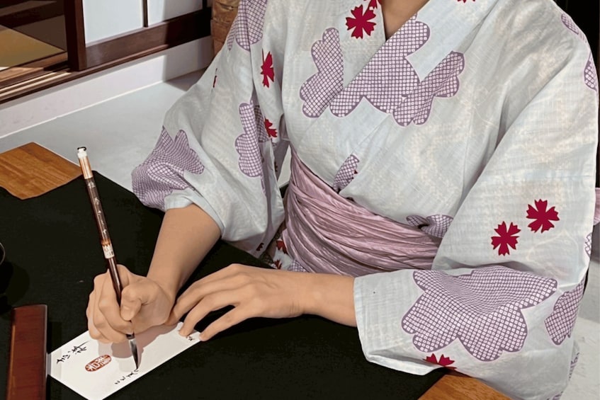 A person writing on a piece of paper with a pen. 2
