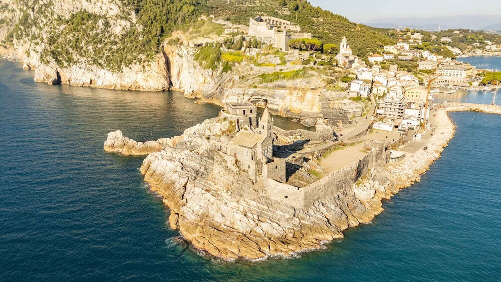 A coastal town with historic stone buildings and a fortified structure on a rocky outcrop. 2