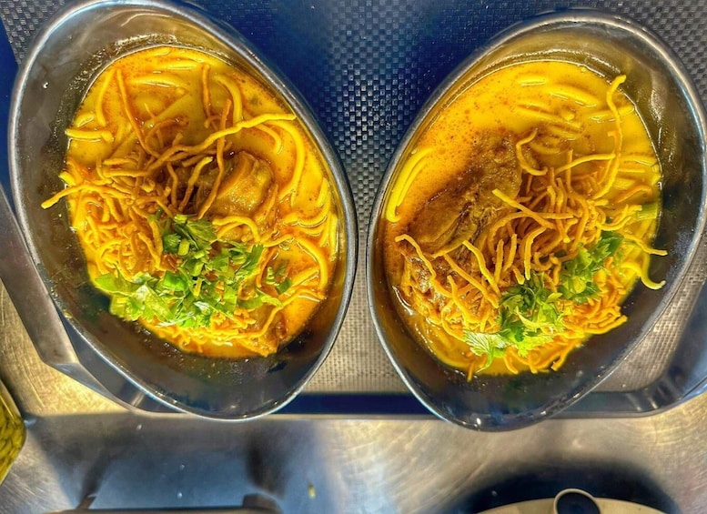 Due ciotole di zuppa di noodles con carne e guarnite di erbe verdi. 2