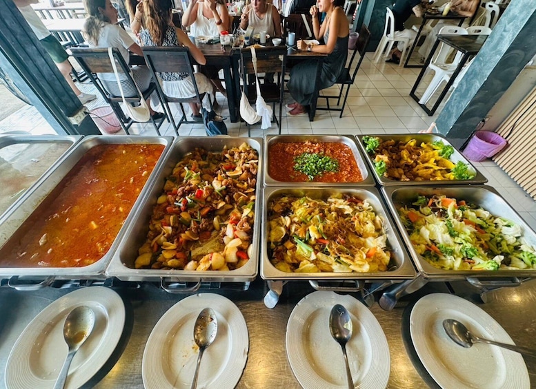 Un buffet con diverse opzioni gastronomiche, tra cui un sugo rosso, un piatto con carne e verdure, e un'insalata. 4