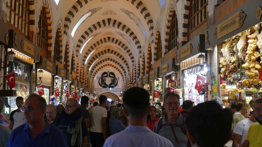A bustling indoor market with a central archway and shops on either side. 3