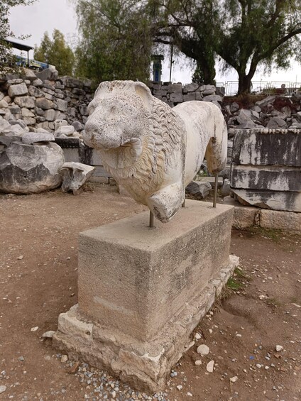 Una estatua de león de piedra sobre un pedestal en un entorno exterior. 2