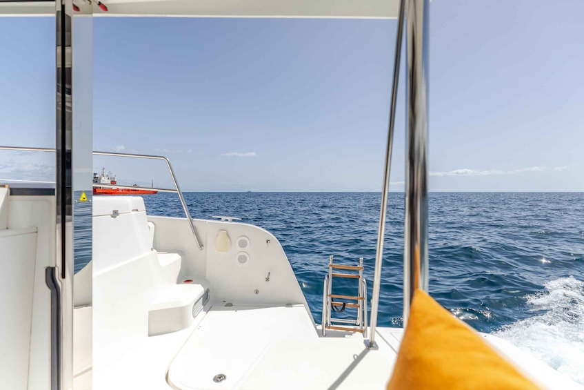A boat's interior with a view of the ocean and another boat in the distance. 2