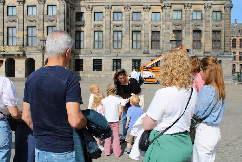A group of people standing in front of a historic building with columns and arched windows. 4