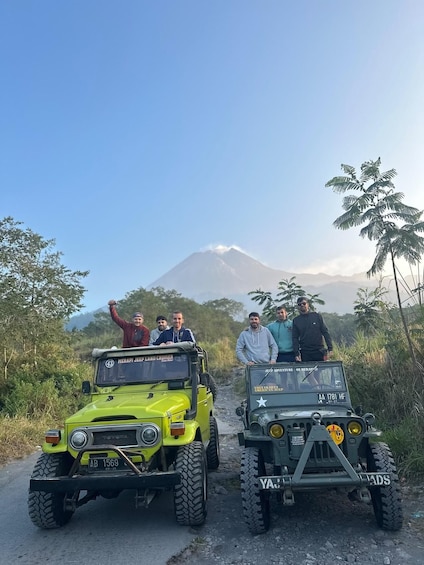 Two off-road vehicles on a dirt path with a mountain in the background. 1