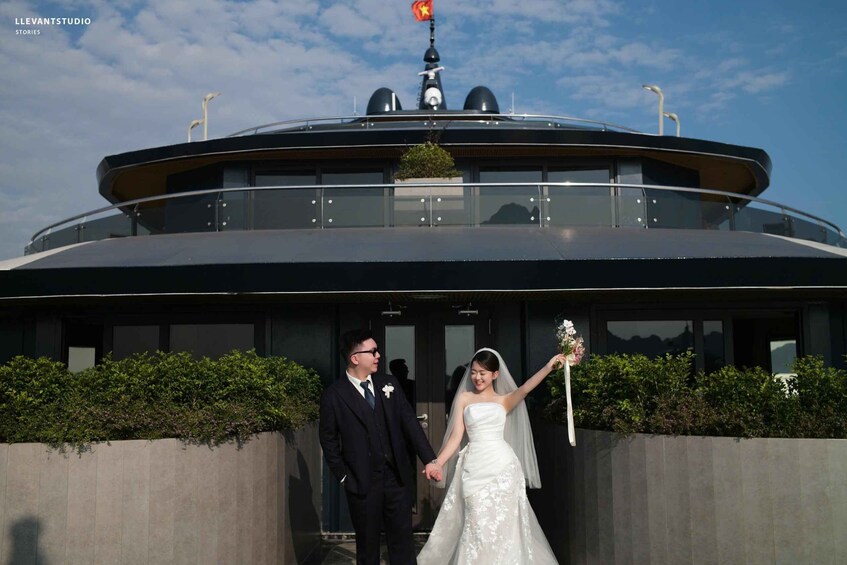 A couple holding hands in front of a modern building with a flag on top. 4
