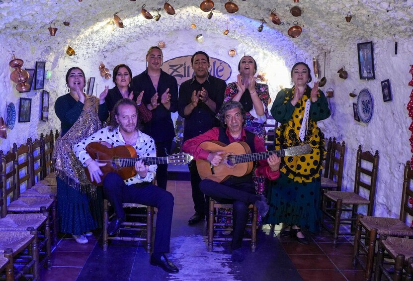 Un grupo de personas en un entorno rústico, con paredes de piedra y sillas de madera. 2