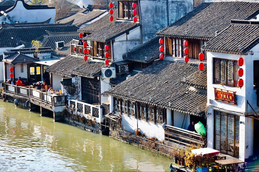 A traditional Chinese water village with tiled roofs and red lanterns. 2